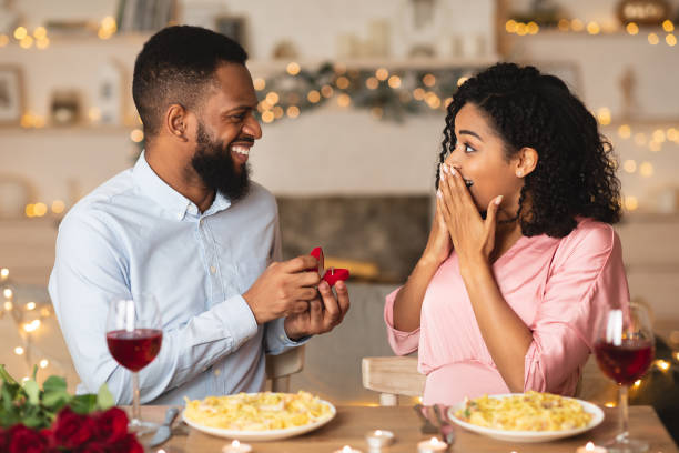 istock Young black man making proposal with ring to his woman 1297777829