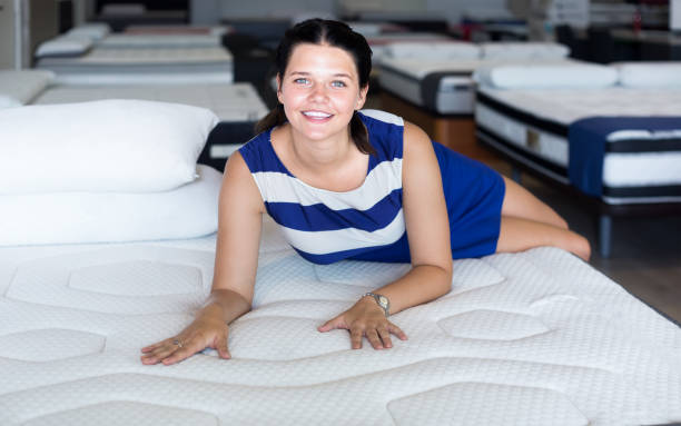 istock Young woman is lying on bed and testing mattress for relax 1297778576