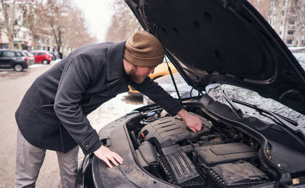 junger mann untersucht den automotor, weil sie nicht starten - vehicle breakdown hood car oil change stock-fotos und bilder