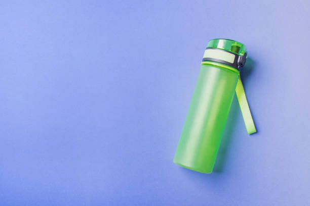 istock green plastic sport bottle lying on right side of blue background with copy space 1297780198