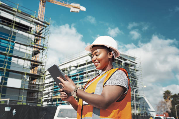 Making paper blueprints a thing of the past Shot of a young woman using a digital tablet while working at a construction site construction worker stock pictures, royalty-free photos & images