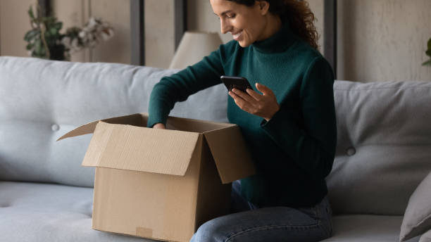 istock Excited woman unbox package shopping online on cell 1297781533
