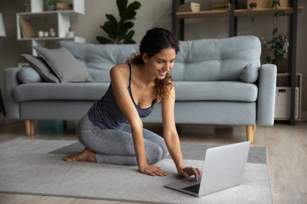 istock Smiling woman train online using laptop at home 1297781556