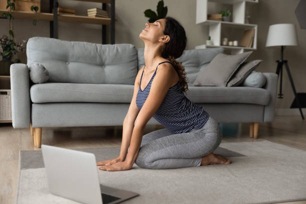 istock Young sporty woman train at home using laptop 1297781561