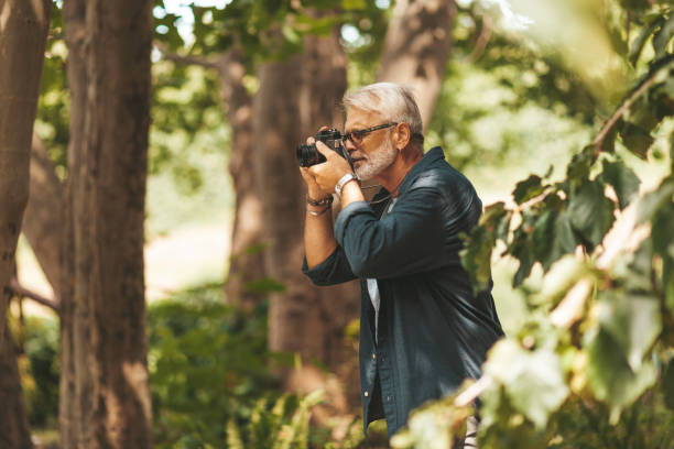 istock A modern old man with a camera in his hands on a walk in the forest 1297781842