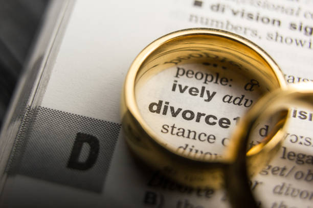 concepto de divorcio y separación. dos anillos de boda dorados. definición de diccionario. - divorcio fotografías e imágenes de stock