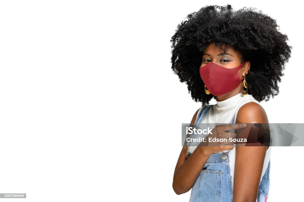 adolescent noir utilisant le masque protecteur contre covid-19 avec un sourire sur son visage montre la marque de vaccin, isolée sur le fond blanc - Photo de Vaccin libre de droits