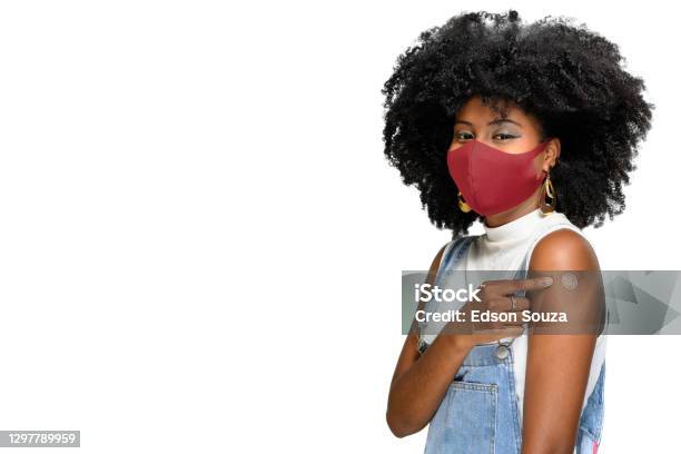 Photo libre de droit de Adolescent Noir Utilisant Le Masque Protecteur Contre Covid19 Avec Un Sourire Sur Son Visage Montre La Marque De Vaccin Isolée Sur Le Fond Blanc banque d'images et plus d'images libres de droit de Vaccin