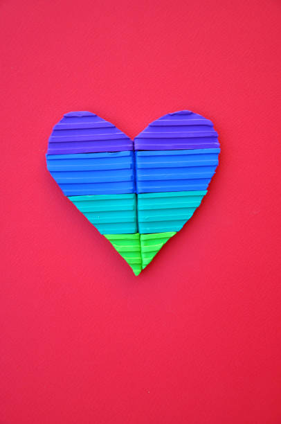 istock Vibrant multi coloured heart shape made with plasticine on bright complimentary coloured paper 1297796758