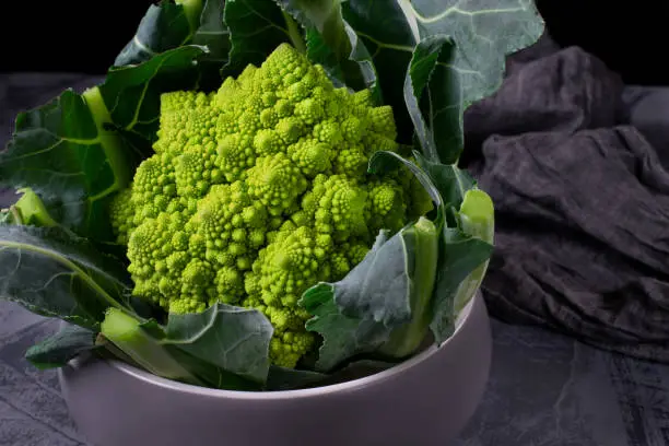 Romanesco broccoli in the ceramic bowl against the dark background