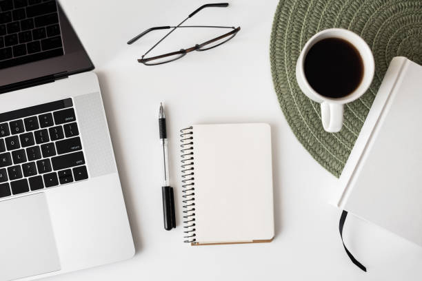 istock Place of work. Laptop, empty blank note pad, coffee at office desk 1297796866