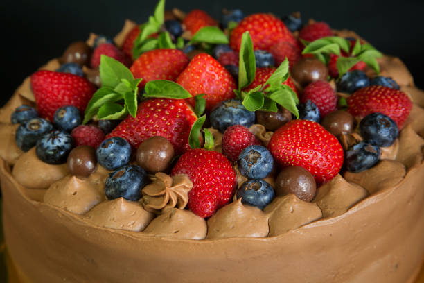 istock chocolate cake decorated with strawberries, raspberries and blueberries, top view. 1297797904