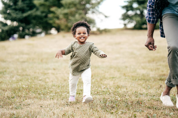 istock Toddler and dad walking together on a field 1297798321