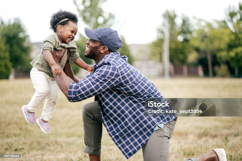 Emotional development Father holding up his toddler in a field. Father Stock Photo