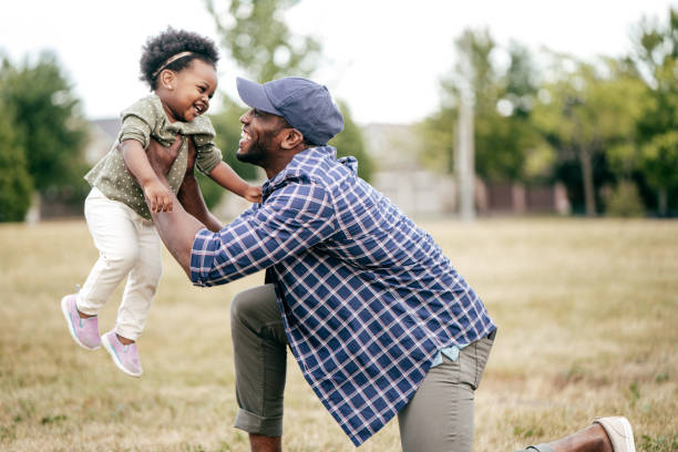 Emotional development Father holding up his toddler in a field. father and baby stock pictures, royalty-free photos & images