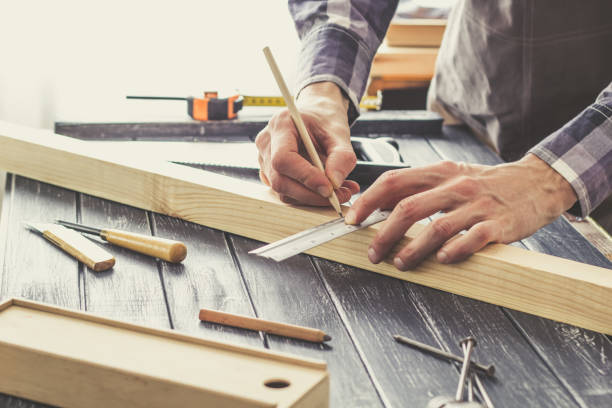 istock Carpenter works in a workshop with wooden planks. 1297799235