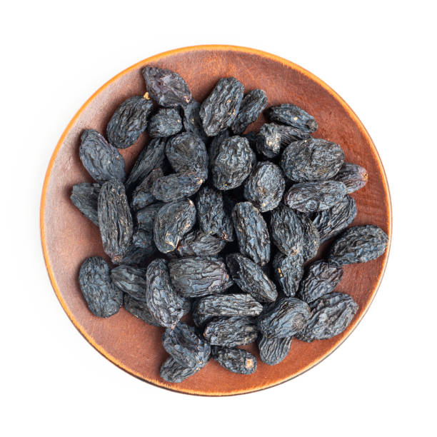istock Dark blue raisins on a plate isolated on white background, top view 1297800189