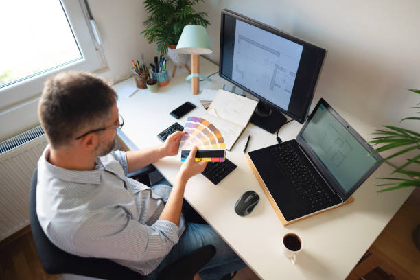 istock Caucasian ethnicity man holding color samples and working on his new project at his home office 1297800780