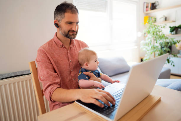 istock Caucasian ethnicity smiling man working from home while babysitting 1297800822