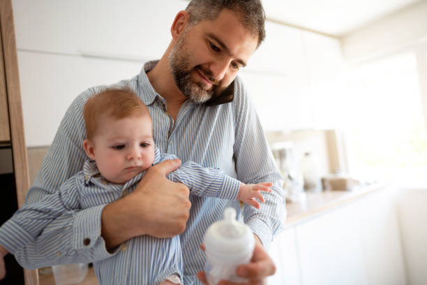 istock Mid-adult man working and babysitting 1297800825