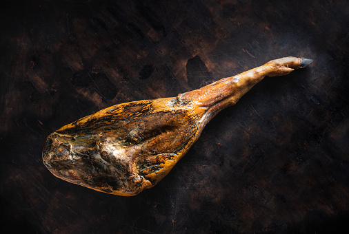 Iberian ham Iberic ham leg black hoof whole jamon iberico serrano from Spain on moody dark background