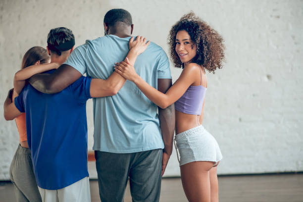 istock Three friends standing with their backs and smiling girl 1297804495