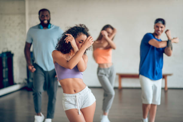 istock Young girl with colleagues rehearsing dance 1297804547