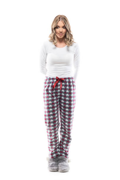istock Cute young woman in pajamas with hands on back looking down thinking and having plan. 1297805807