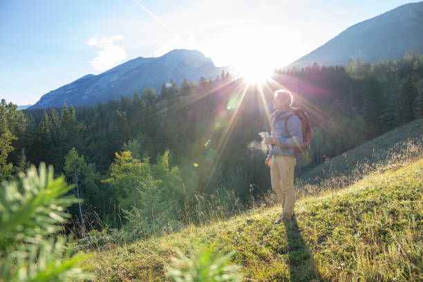 istock Male hiker walks along forested trail at sunrise 1297808459