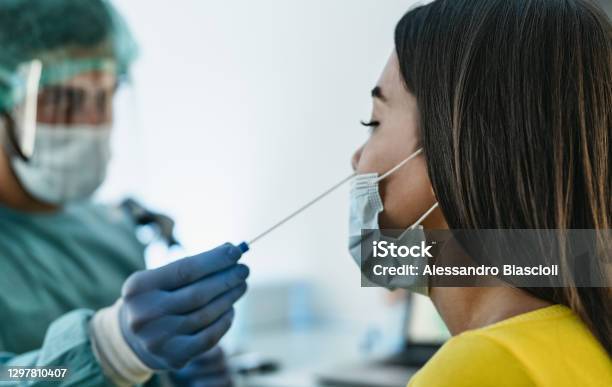 Medical Worker Wearing Personal Protective Equipment Doing Corona Virus Swab On Female Patient Covid19 Test And Health Care Concept Stock Photo - Download Image Now