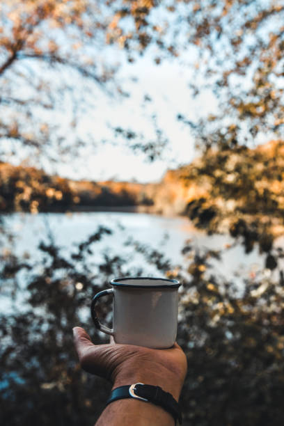 istock hand holding cup of coffee on natural background 1297811992