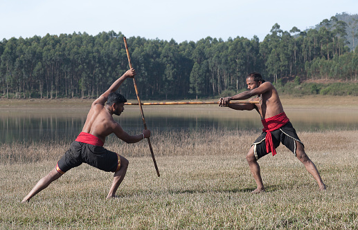 Indian fighters with bamboo sticks performing Kalaripayattu Martial art demonstration in Kerala, South India