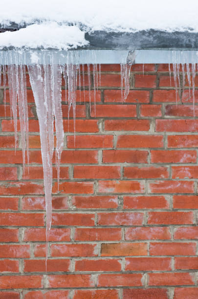 istock icicles on a background of red brick wall 1297813388