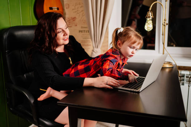 istock the little daughter prevents the freelancer mother from working on the computer. 1297813792