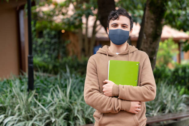 istock Male student wearing a facemask at the university 1297813828