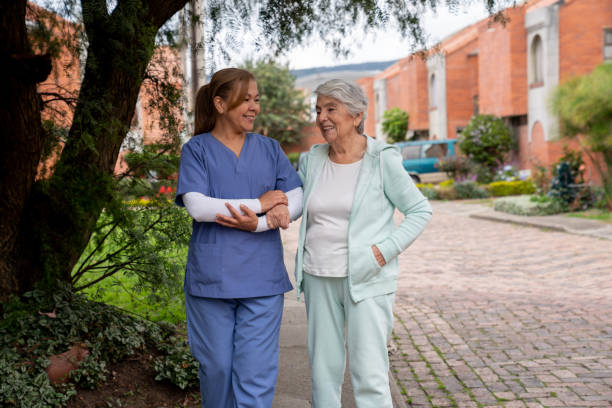 istock Caregiver walking outdoors with a senior woman 1297814547