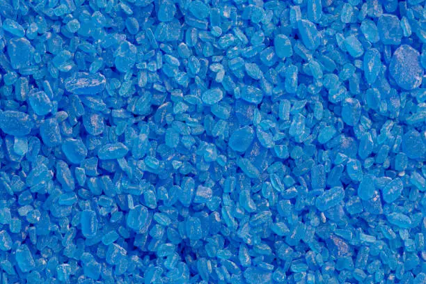 full frame background and texture of blue copper sulfate granules - close-up.