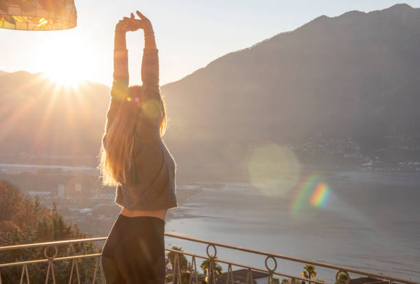 istock Young woman relaxes on balcony at sunrise 1297817604