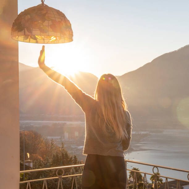 istock Young woman relaxes on balcony at sunrise 1297817626
