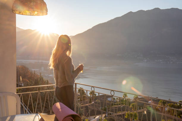 istock Young woman relaxes on balcony at sunrise 1297817643