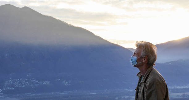 istock Man wearing protective face mask relaxes outside at sunrise 1297817869