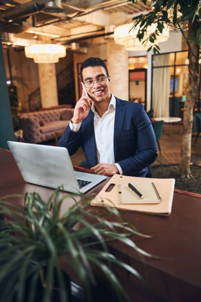 istock Cheerful businessman in eyeglasses making a phone call 1297822111