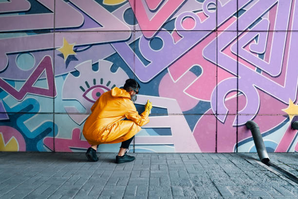 istock Street artist painting colorful graffiti on wall 1297823607