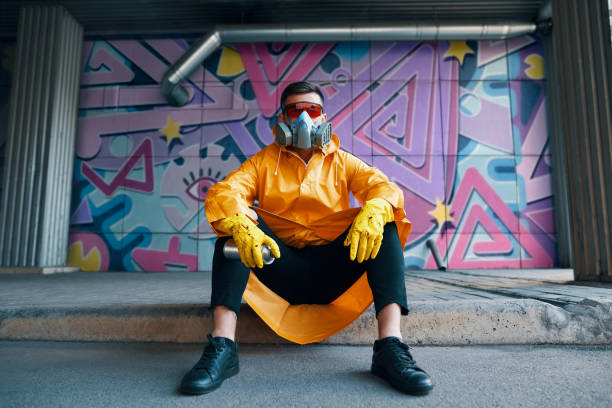 istock Graffiti painter rest near the wall with his paintings looking to camera 1297823608