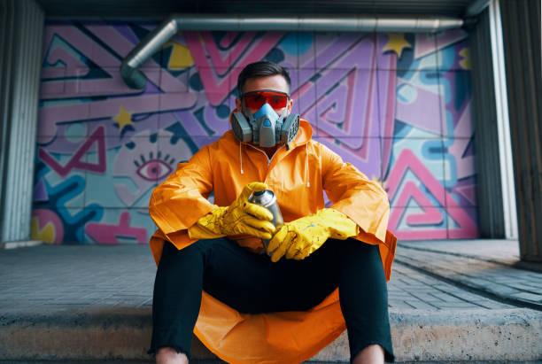 istock Graffiti painter rest near the wall with his paintings looking to camera 1297823610