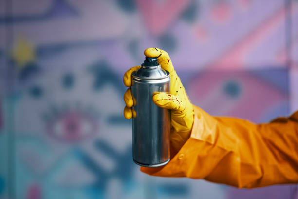 Graffiti artist pointing spray paint can to camera. Urban street? modern art concept