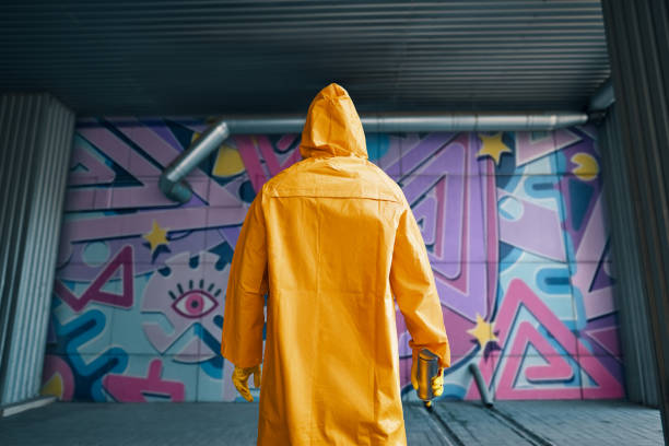 imagen recortada del artista callejero con pintura en aerosol en la mano de pie cerca de la pared - graffiti men wall street art fotografías e imágenes de stock
