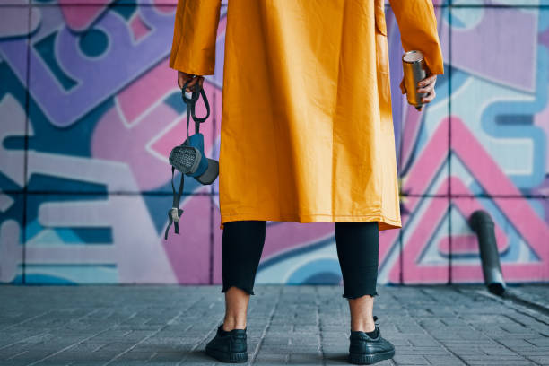 cropped image of street artist with spray paint can in hand standing near the wall - graffiti men wall street art imagens e fotografias de stock