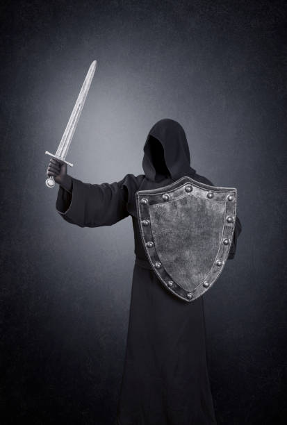 istock Ghostly figure with medieval sword and shield in the dark 1297824389