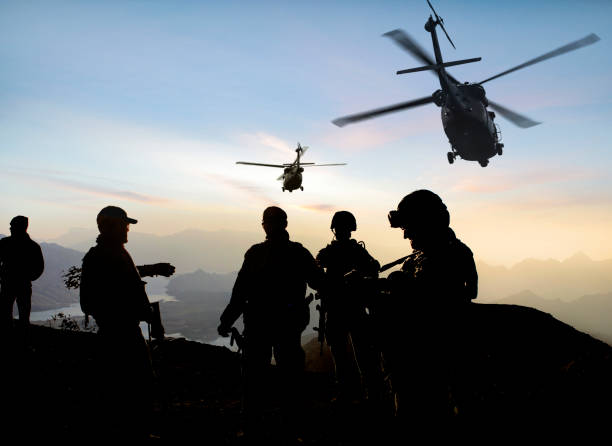 silhouetten von soldaten während der militärmission in der abenddämmerung - commando stock-fotos und bilder